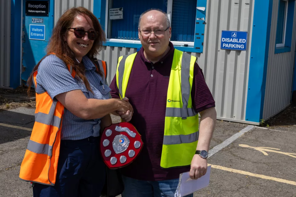 a man presents a trophy to a womman