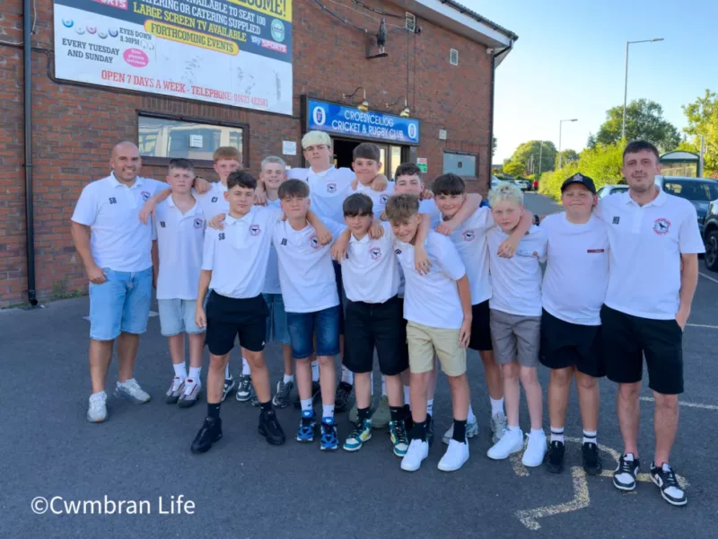 a group of under 13s boy footballers with their two coaches