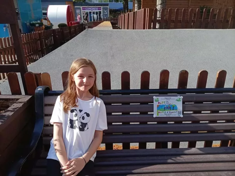 a girl sitting on a wooden bench
