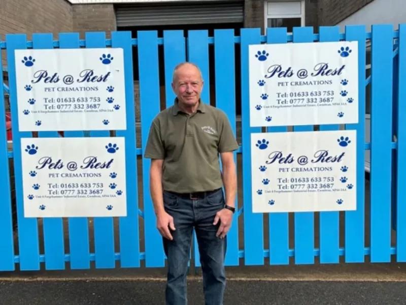 a man stood in front of blue gates