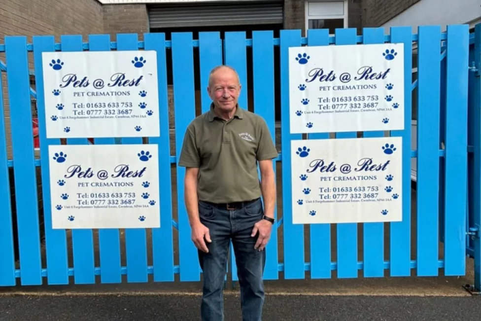a man stood in front of blue gates