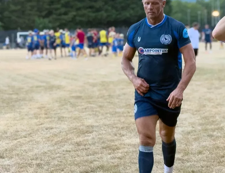 a footballer walks off a pitch
