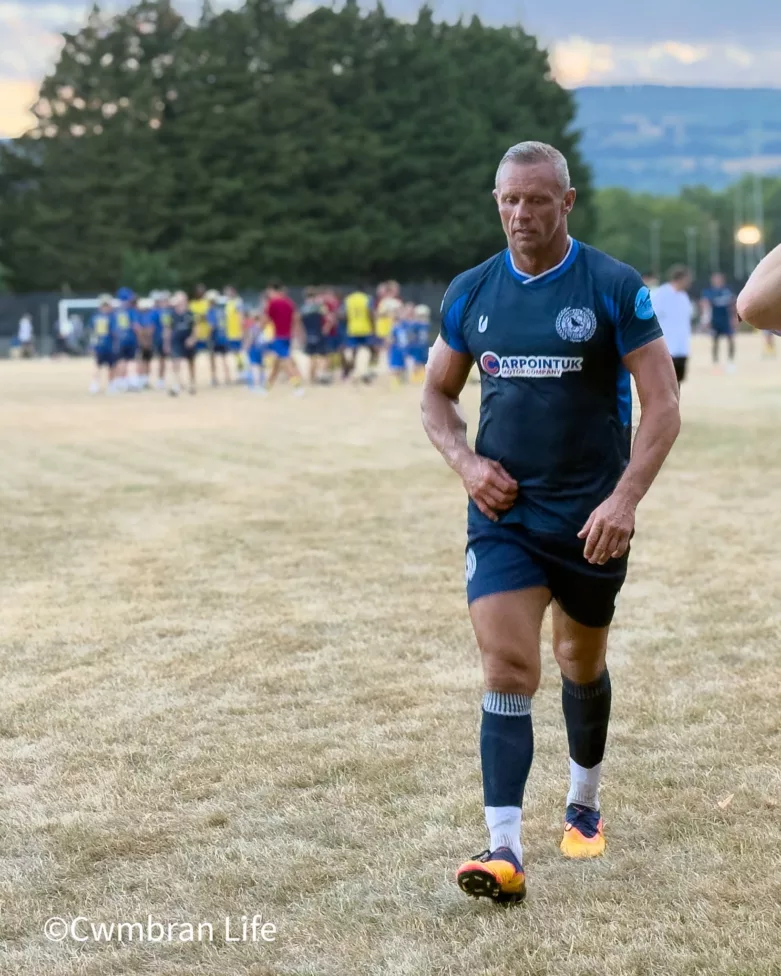 a footballer walks off a pitch