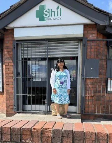a woman stood outside the entrance to a pharmacy called Shil Pharmacy