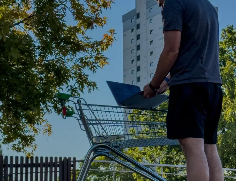 a man stood by a shopping trolley