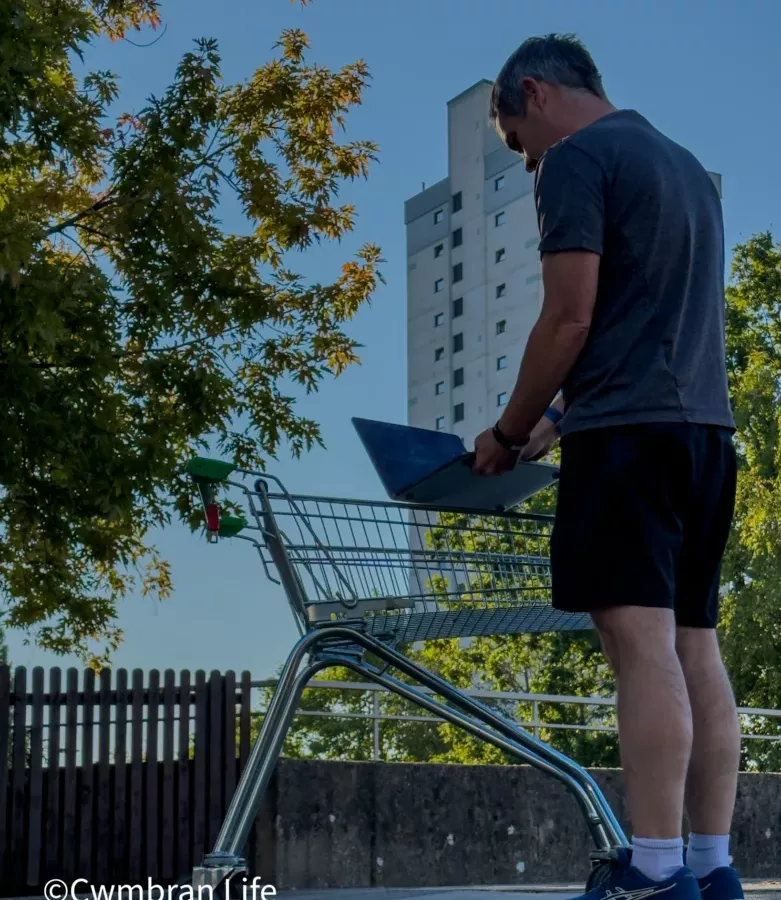 a man stood by a shopping trolley