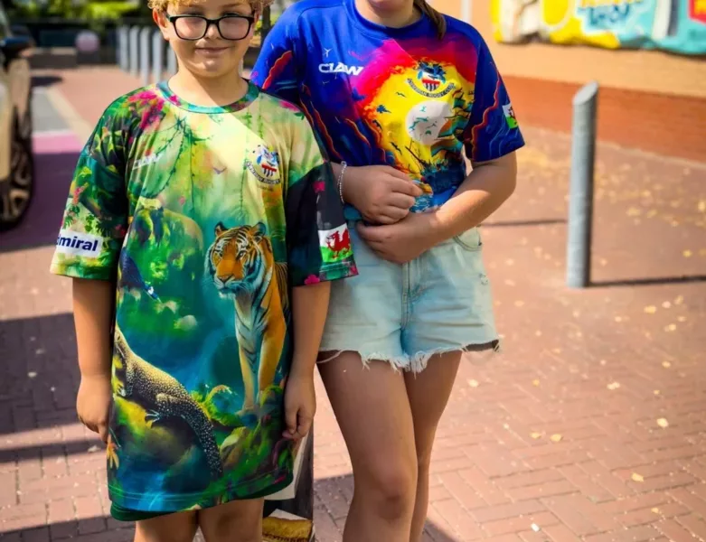 a brother and sister, aged 8 and 13, stood next to each other