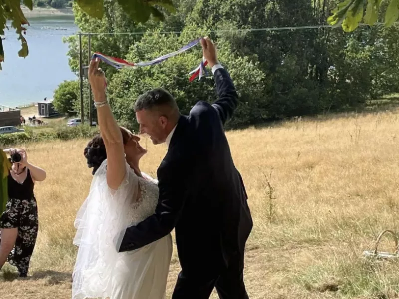 a man and woman hug during their wedding outside in field
