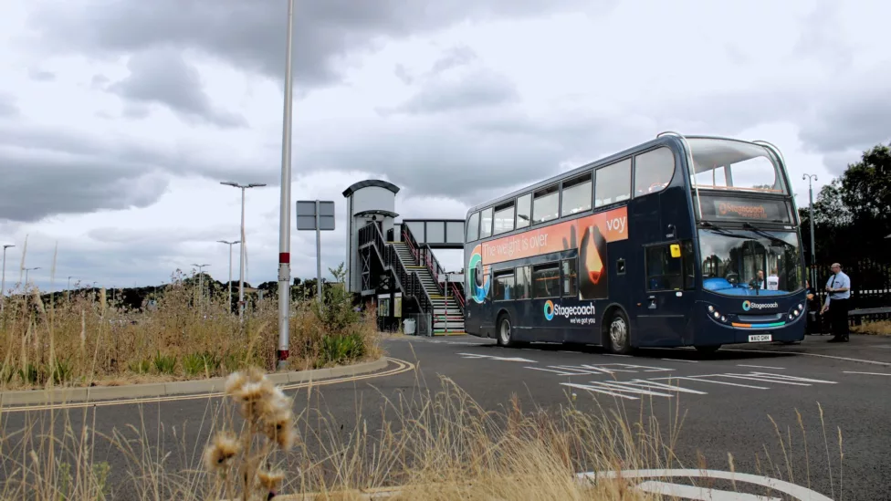 a double decker bus parked outside a train station