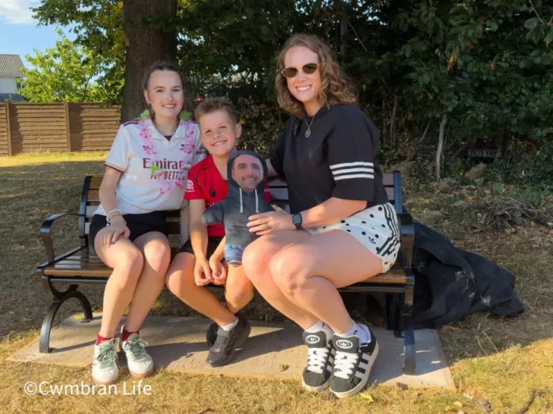 a mum and two of her children sat on a bench