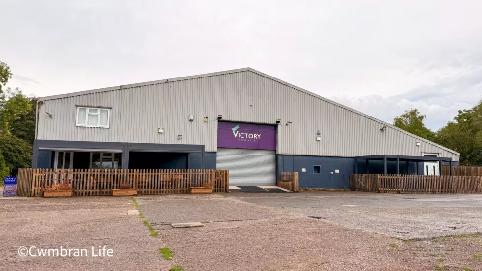 a large industrial unit ith a sign saying victory church above the door