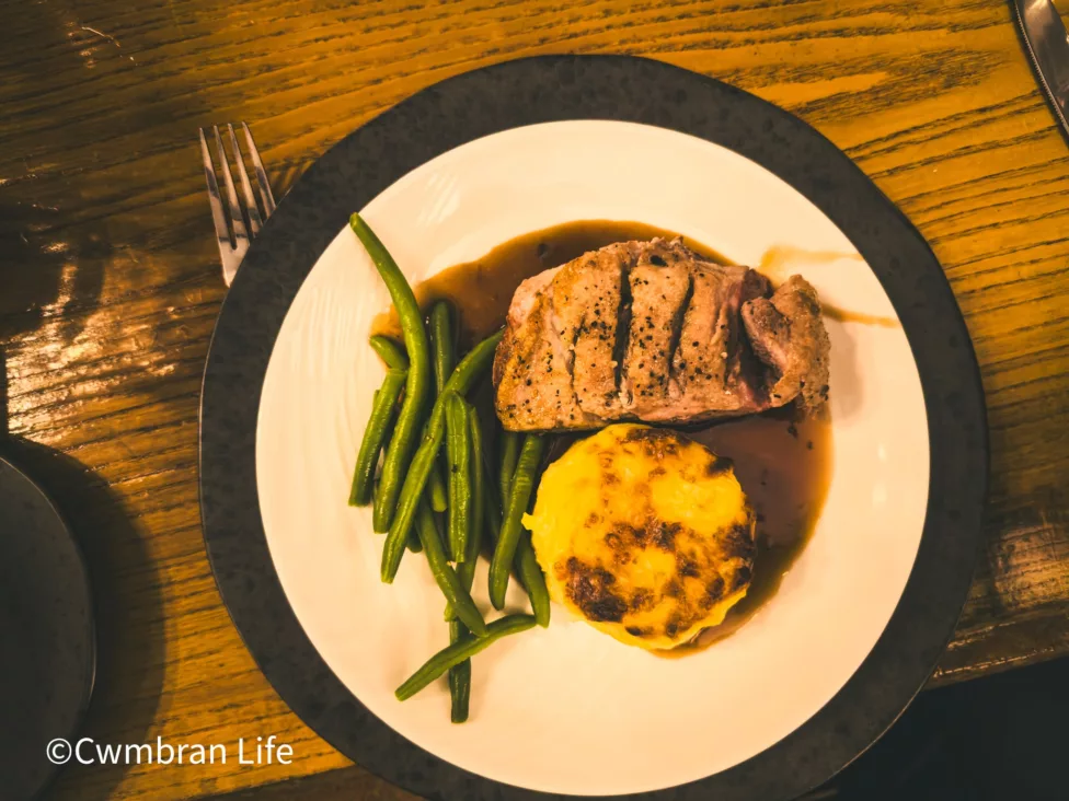 a plate of duck breast, beans and potatoes