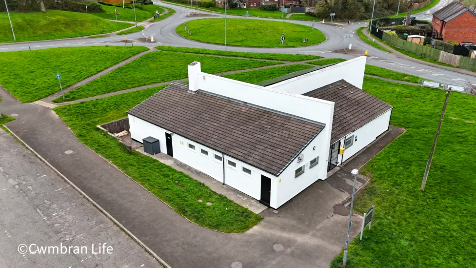 a drone photo of a community hall and car park
