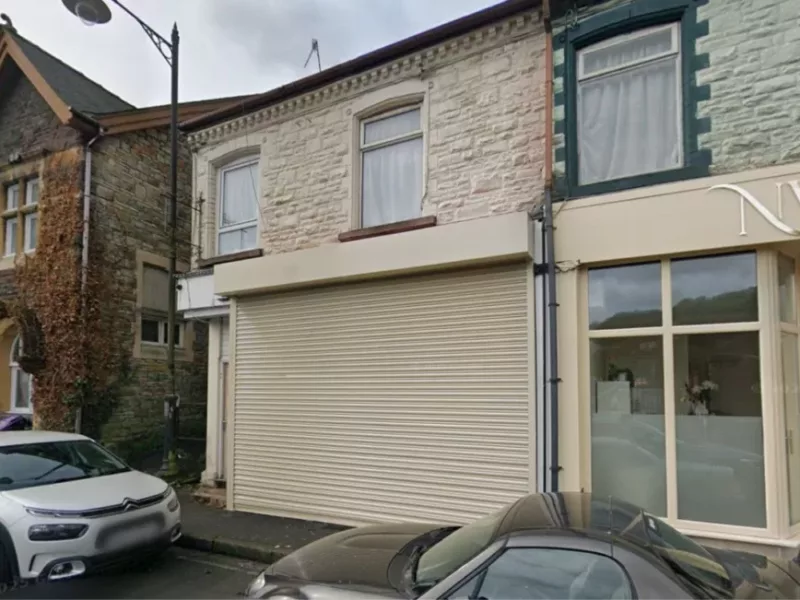 a shop with shutters over the windows