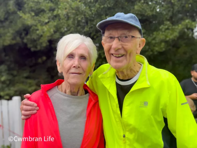 a man and woman in bright clothing after running a 5km race