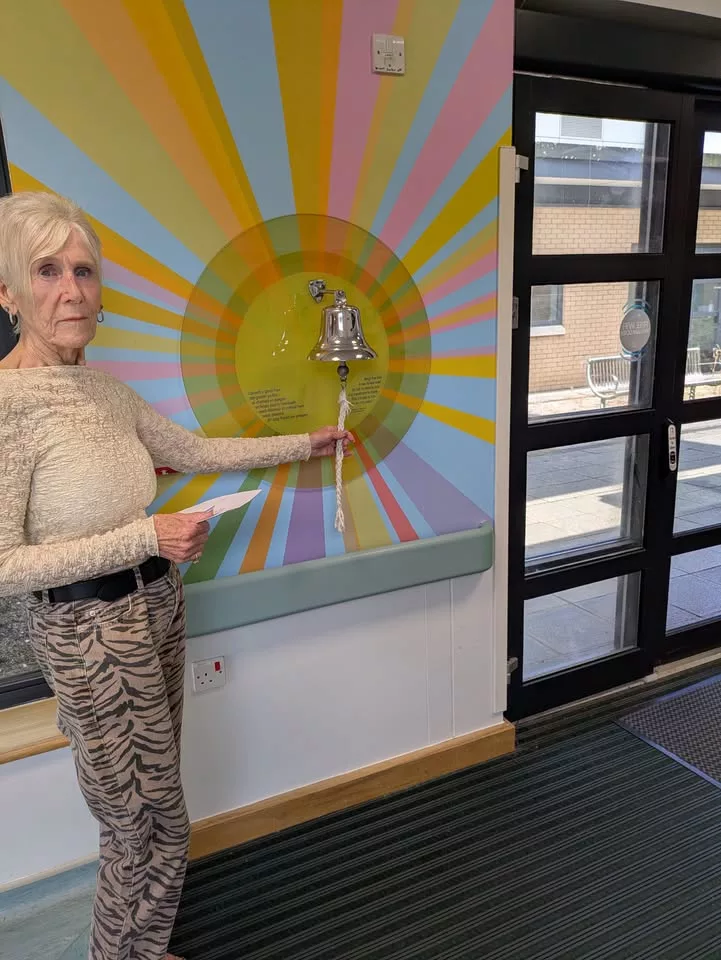 a woman stood by a bell in a hospital