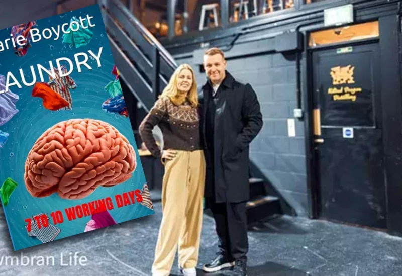 a man and woman stood in a warehouse with a book added to photo- the book is called '"Laundry - 7 to 10 Working Days'