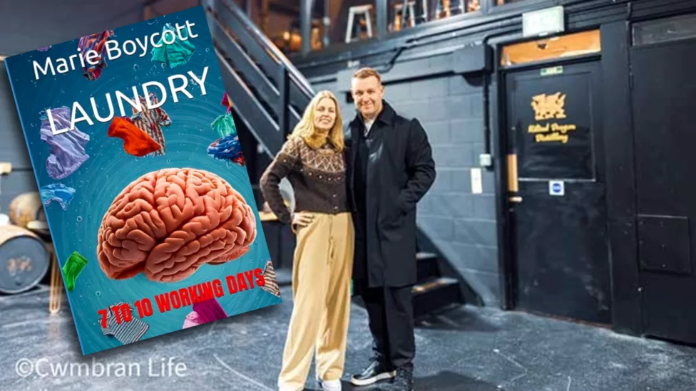a man and woman stood in a warehouse with a book added to photo- the book is called '"Laundry - 7 to 10 Working Days'
