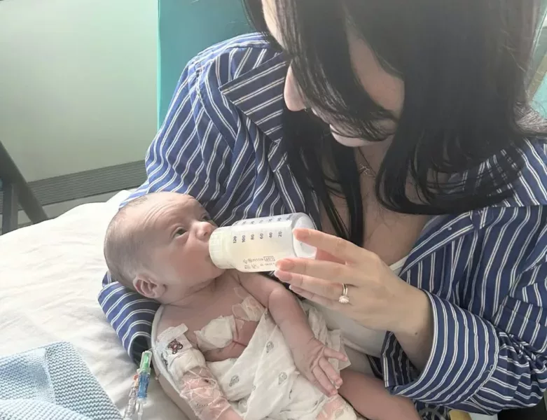 a woman feeding a baby with a bottle