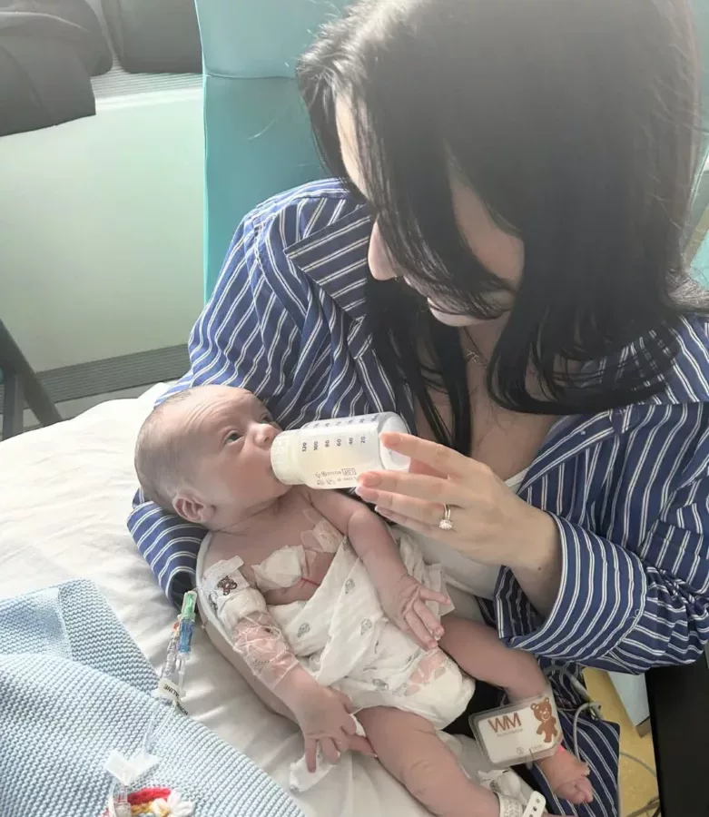 a woman feeding a baby with a bottle